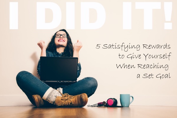 Girl sitting on the floor with a laptop raising his arms with a look of success